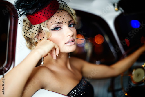Photo: beautiful fashion girl in retro style sitting in old car beautiful fashion girl in retro style sitting in old car