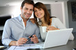 Couple at home looking at future home blueprint