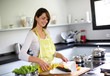 Woman in kitchen preparing fish dish