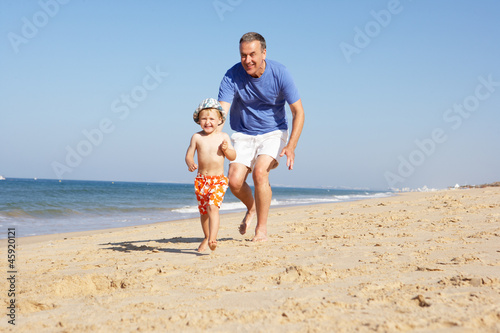 Photo: Grandfather And Grandson Running Along Beach Grandfather And Grandson Running Along Beach