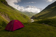 Red tent in caucasus valley with Mt. Shkhara in background