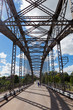 Old arched metal bridge in Novgorod region, Russia. View from in