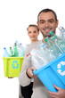 Couple recycling plastic bottles