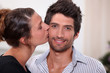 Woman kissing man on the cheek