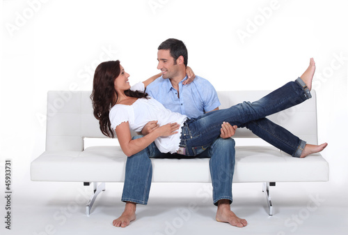 Photo: Happy couple on white sofa Happy couple on white sofa