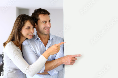 Photo: Cheerful couple looking at message on whiteboard Cheerful couple looking at message on whiteboard
