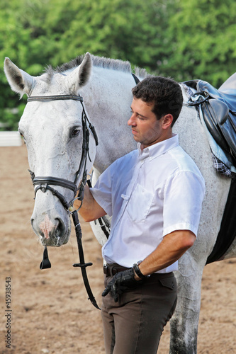Photo: Jockey in gloves hug horse on hippodrome Jockey in gloves hug horse on hippodrome