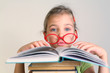 Photo: Little girl in red glasses read book Little girl in red glasses read book