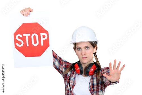 Photo: A road worker holding a stop sign. A road worker holding a stop sign.