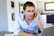 Home office worker talking on mobile phone