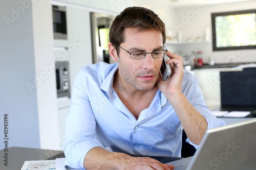 Photo: Home office worker talking on mobile phone Home office worker talking on mobile phone
