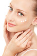 Cute woman applying cream to her face