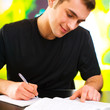 Young happy smiling man writing, outdoor