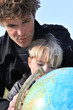 Father and son examining globe
