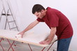 Man with a roll of wallpaper