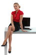 Blond businesswoman sat on desk