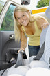 Junge Frau mit Auto-Staubsauger
