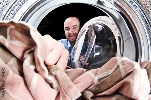 Photo: man load washing machine man load washing machine