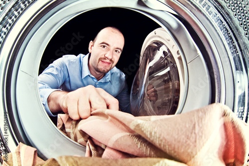 Photo: man load washing machine man load washing machine
