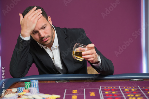 Photo: Man looking at whiskey glass Man looking at whiskey glass