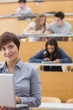 Teacher standing holding a laptop