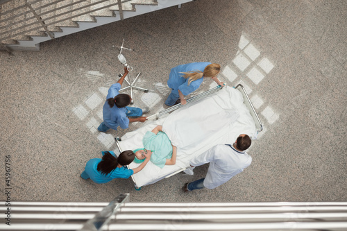 Photo: Three nurses and one doctor pushing one patient in a bed Three nurses and one doctor pushing one patient in a bed