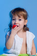 Little girl eating strawberry