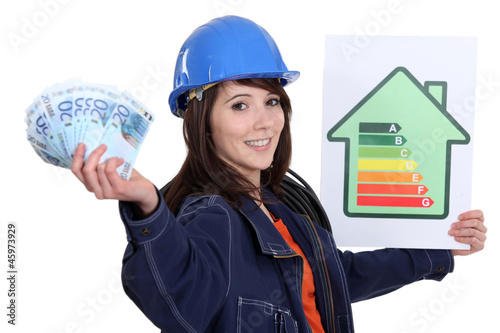 Photo: Tradeswoman holding up an energy efficiency and money Tradeswoman holding up an energy efficiency and money