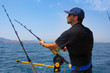 blue sea fisherman in trolling boat with downrigger