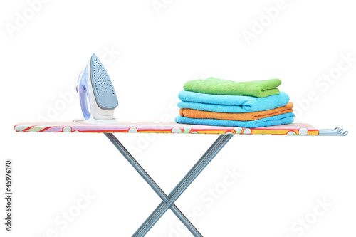 Photo: Studio shot of iron and towels on ironing board Studio shot of iron and towels on ironing board