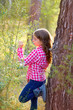 beautiful kid girl profile looking plants in pine forest