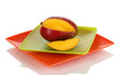 Ripe appetizing mango on red plate isolated on white