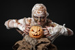 scary mummy holding the pumpkin