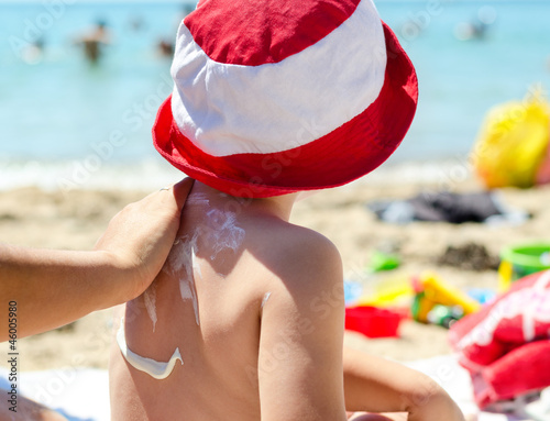 Photo: Young boy having sunscreen applied Young boy having sunscreen applied