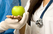Photo: two doctors holding a green apple two doctors holding a green apple