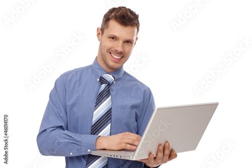 Photo: Happy businessman holding laptop Happy businessman holding laptop