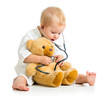 Adorable child with clothes of doctor and teddy bear over white