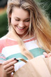 Beautiful smiling girl in park with shopping bags