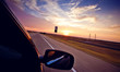 Driving in convertible through highway at sundown