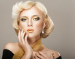 Beautiful woman face with luxury gold makeup