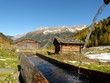 Almhütten mit Holzbrunnen im Herbst