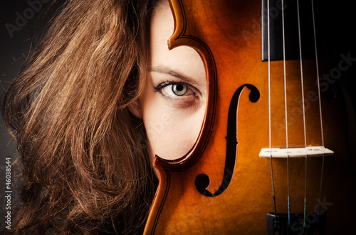 Photo: Woman with violin in dark room Woman with violin in dark room