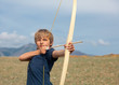 Boy shoots a bow at a target