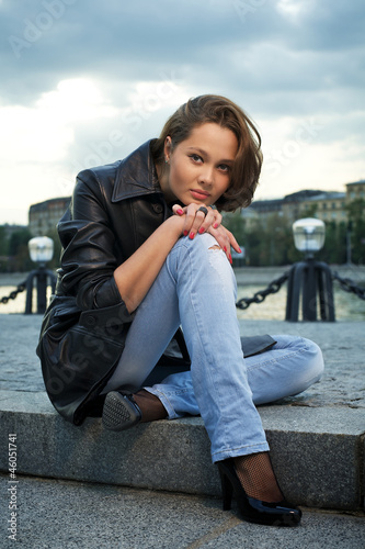 Photo: Beautiful young woman sitting on stone steps Beautiful young woman sitting on stone steps