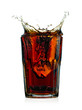 Splashing cola in glass. Isolated on white background