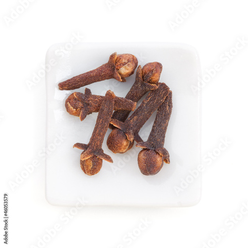 Photo: Clove (Syzygium aromaticum) in a white bowl on white background Clove (Syzygium aromaticum) in a white bowl on white background