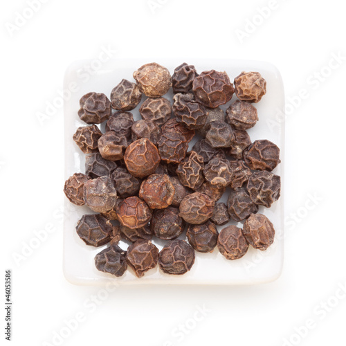 Photo: Black pepper (Piper nigrum) in a white bowl on white background. Black pepper (Piper nigrum) in a white bowl on white background.