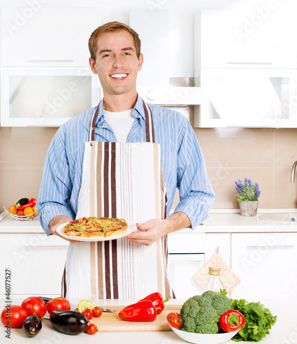 Photo: Young Man Cooking Pizza. Home. Kitchen Young Man Cooking Pizza. Home. Kitchen