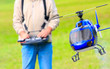 Photo: Piloting radio controlled helicopter with remote control. Piloting radio controlled helicopter with remote control.