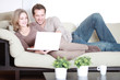 Eheleute mit Laptop auf der Couch